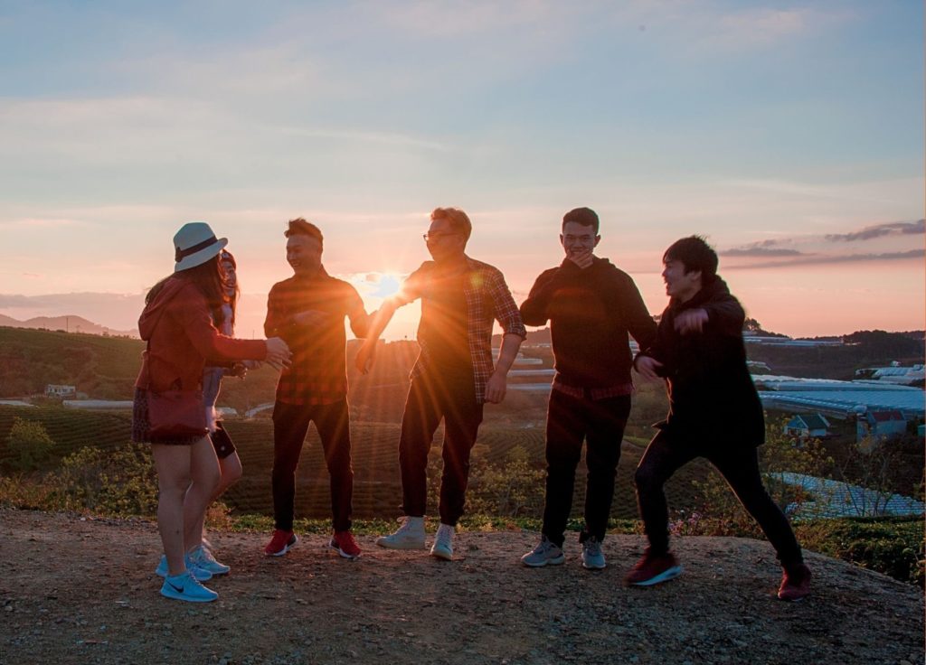 A group of teens or high schoolers at sunset.